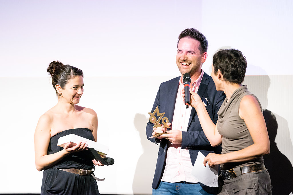 Jason van Genderen receiving his MoMo award for Best Documentary from Monika Schärer and Shalini Allenspach